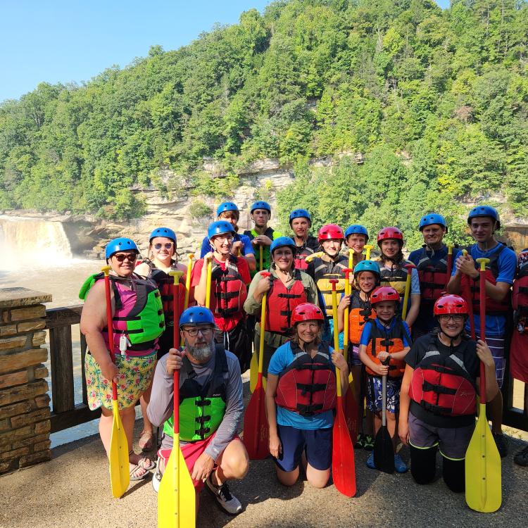  club with paddles, life jackets with waterfall in the background